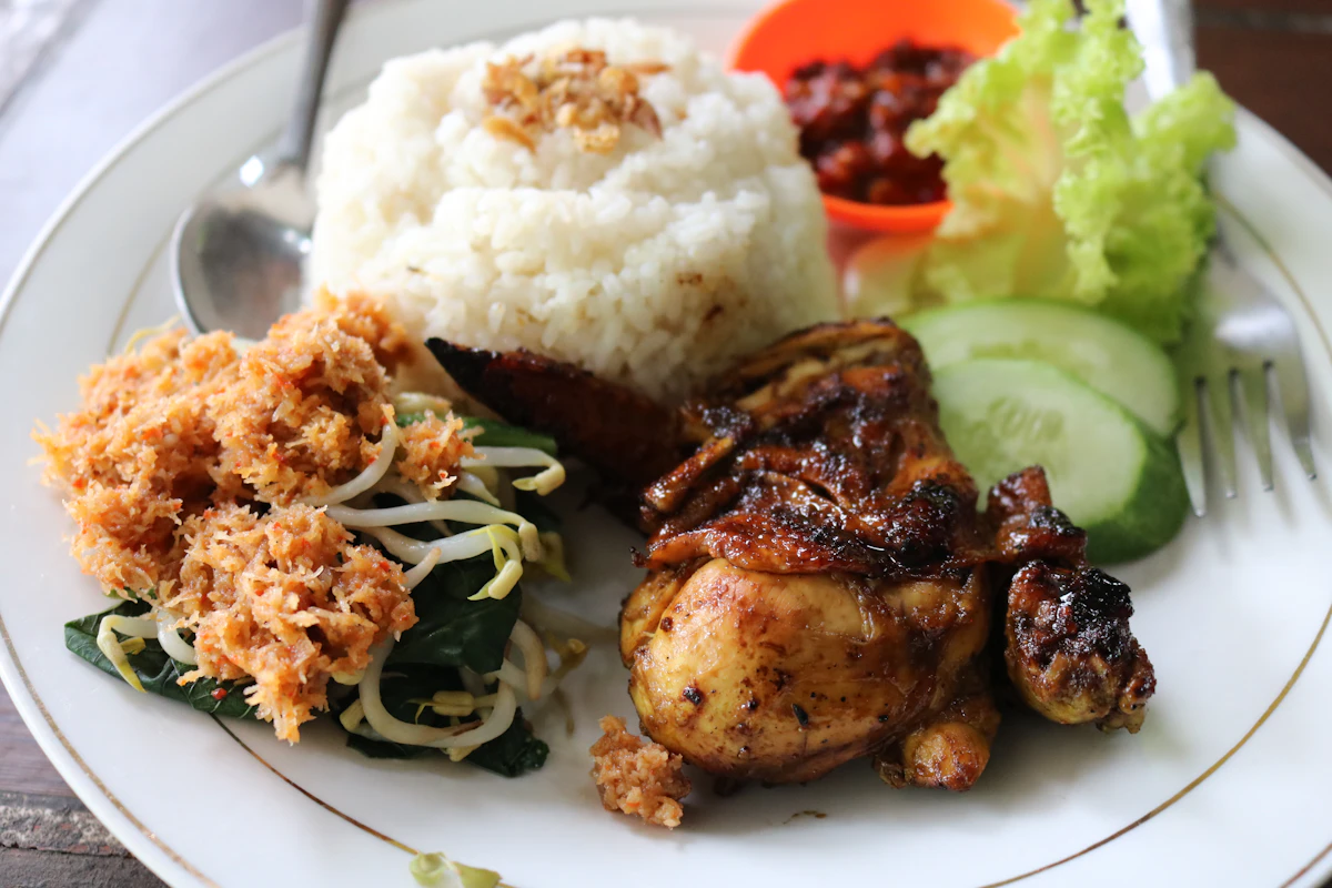 Seporsi nasi dengan ayam goreng dan sambal pendamping
